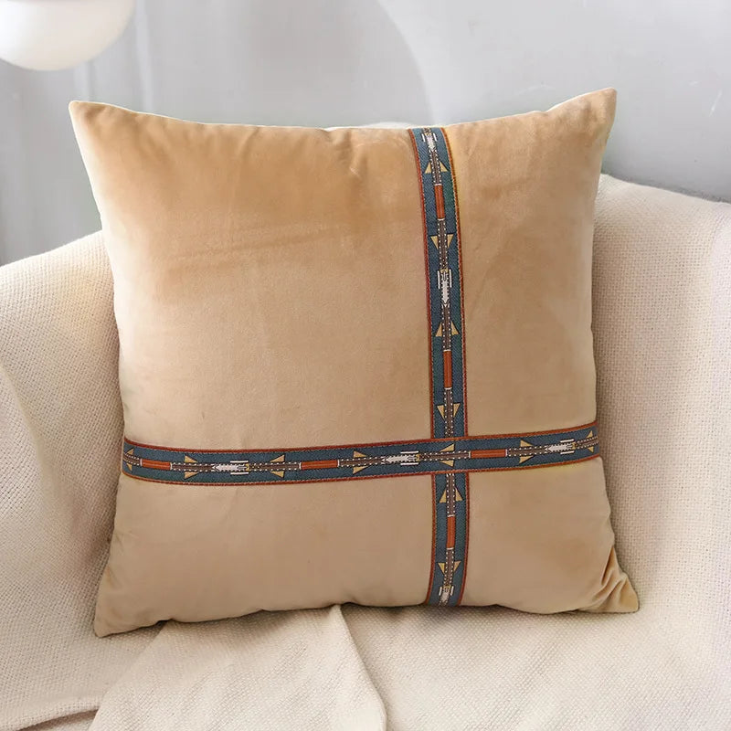 Beige pillow with decorative band on a beige couch