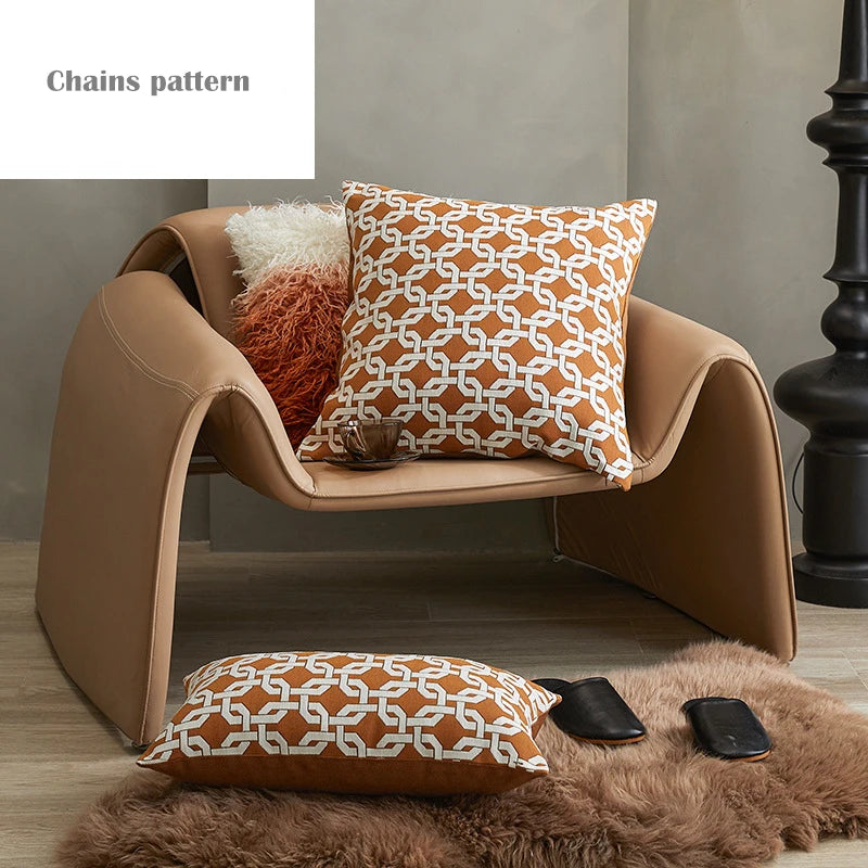 Brown armchair with patterned cushions on a wooden floor.