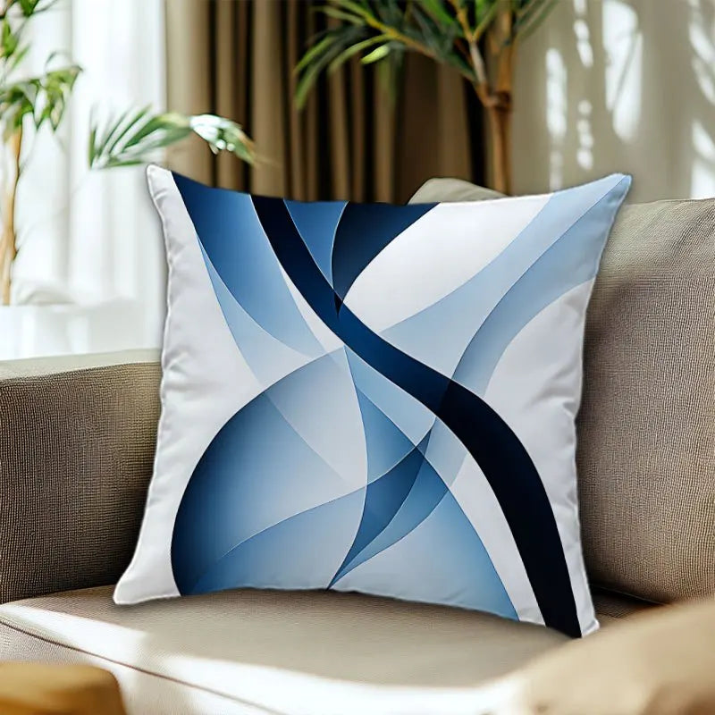 Decorative pillow with blue and black abstract design on a beige couch.