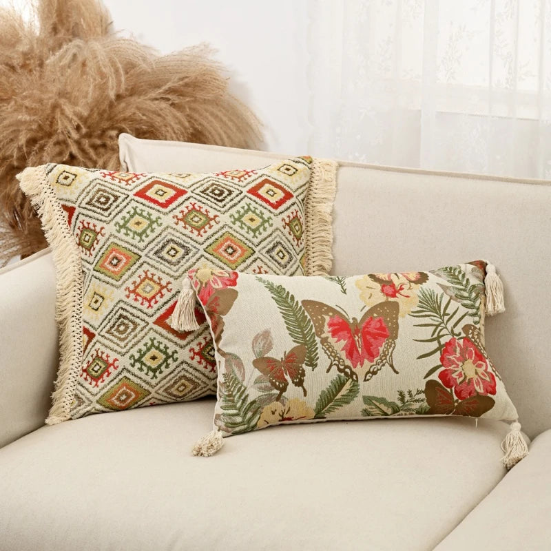 Decorative pillows with geometric and floral patterns on a beige sofa.