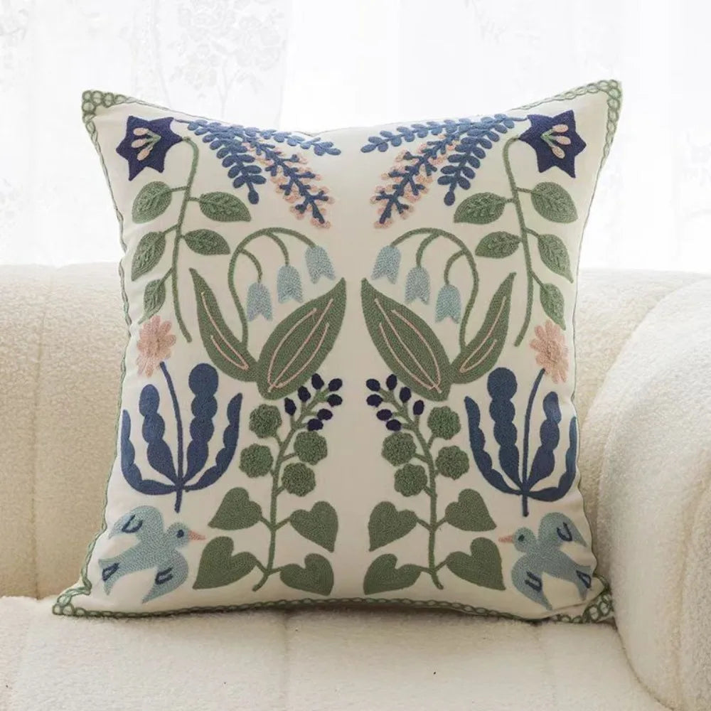 Decorative pillow with floral and bird pattern on a white couch