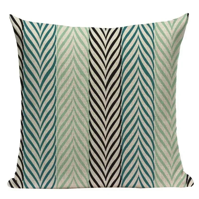 Decorative pillow with chevron pattern in teal, beige, and black on a white background