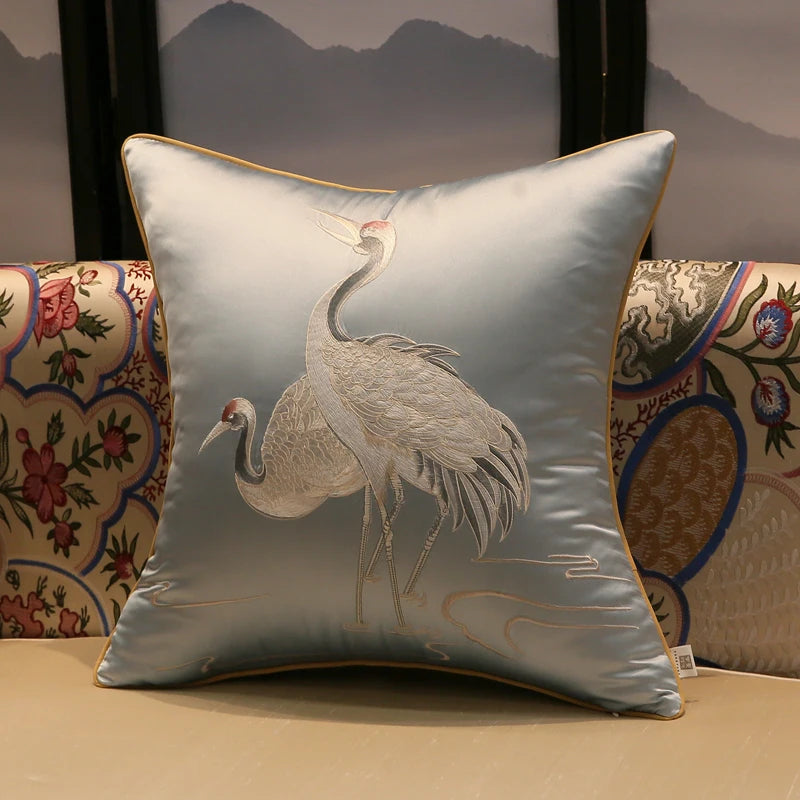 Decorative pillow with crane design on a floral-patterned chair