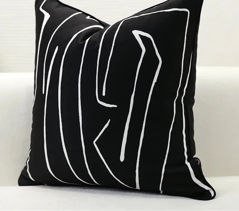 Black pillow with white abstract lines on a white background