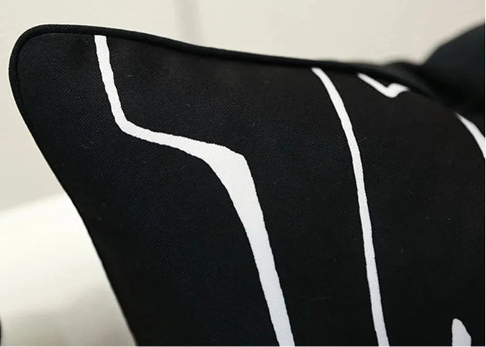 Black pillow with white stripes on a neutral background