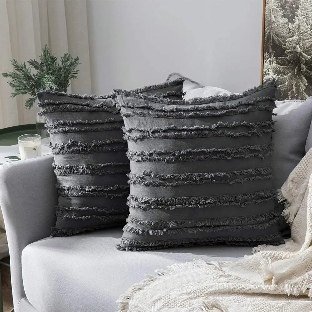 Gray textured pillows on a gray sofa with a neutral background