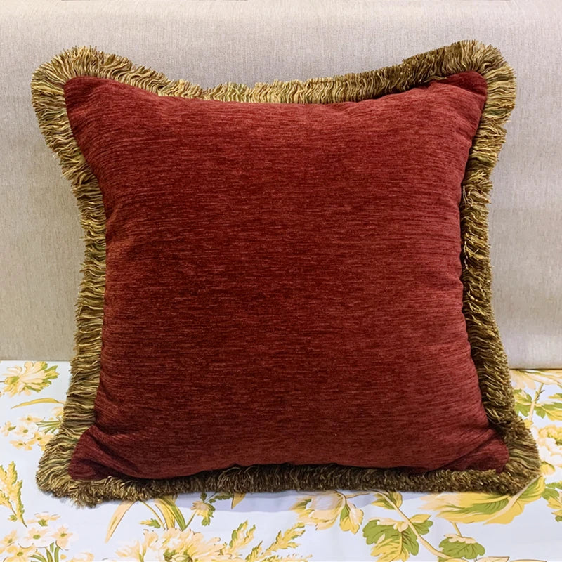 Red pillow with gold trim on a floral-patterned surface