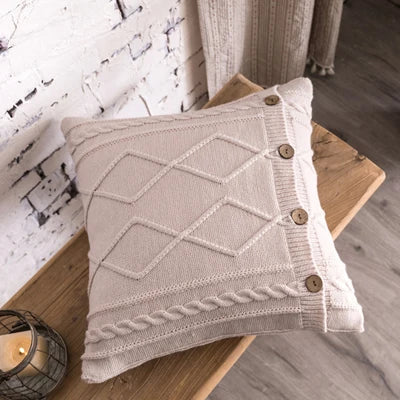 Ivory cable knit pillow cover with textured diamond pattern and wooden buttons
