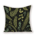 Decorative pillow with green leaf pattern on a black background