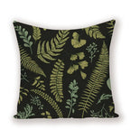 Decorative pillow with green leaf pattern on a black background