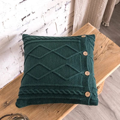 Dark green knitted cushion cover with cable knit diamond design and buttons