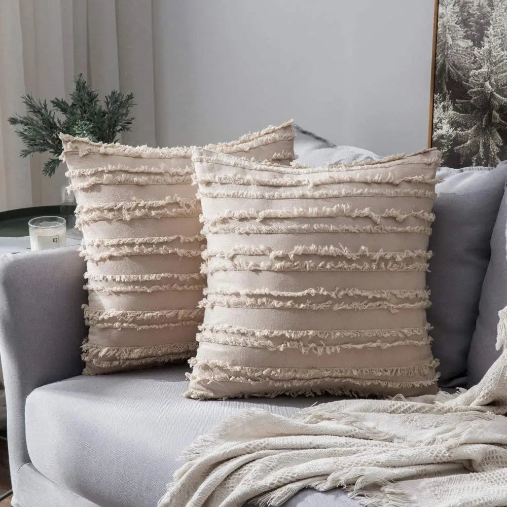 Beige textured throw pillows on a gray sofa with a neutral background