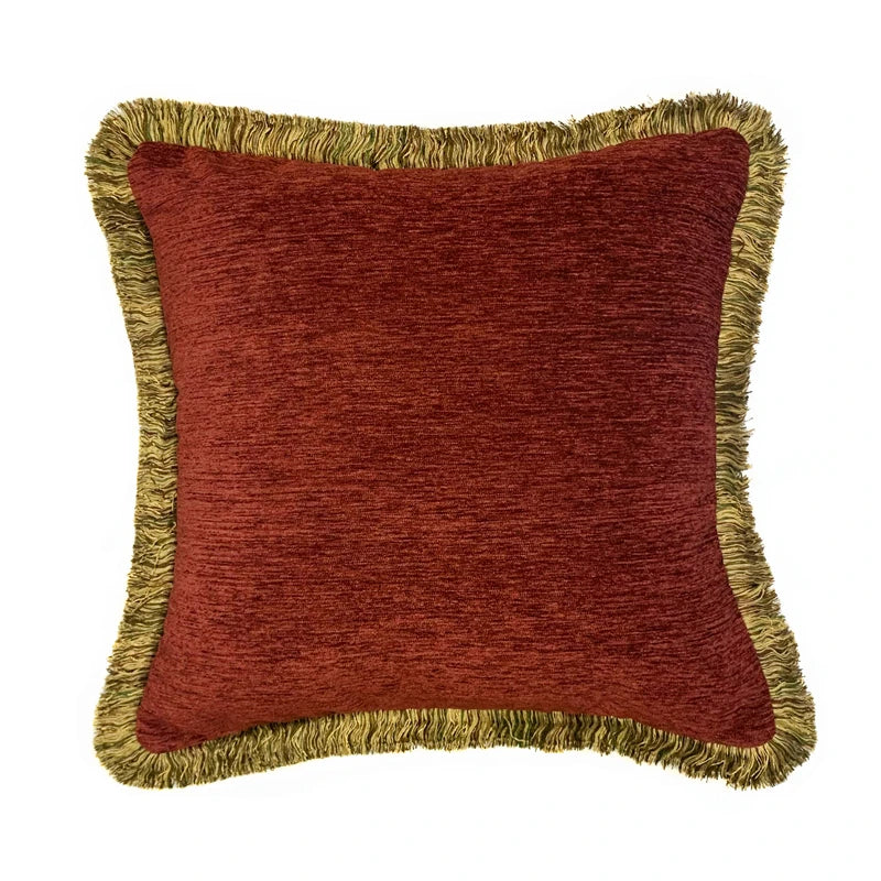 Red pillow with gold fringes on a white background
