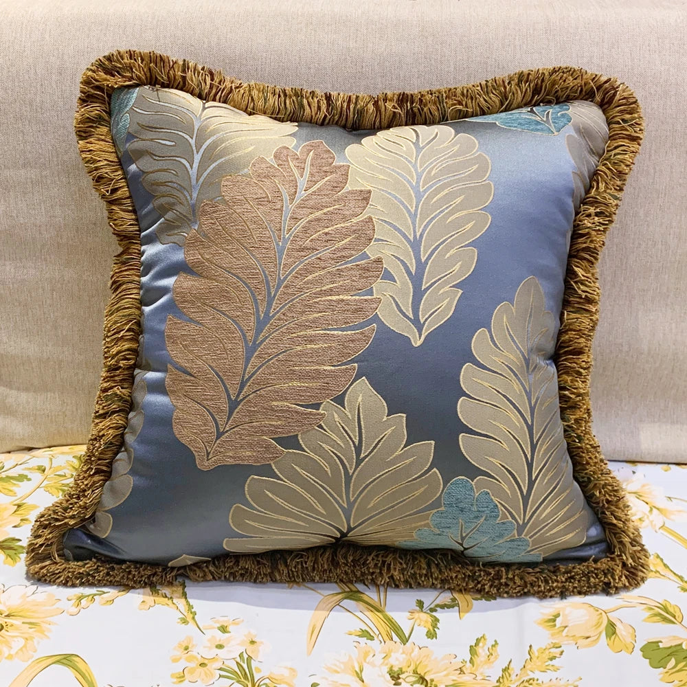Decorative pillow with leaf pattern and brown trim on a floral surface