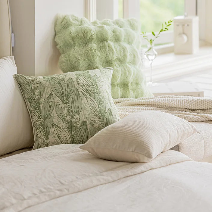 Decorative pillows on a bed with a visible 'Bunny FiFi' brand name.