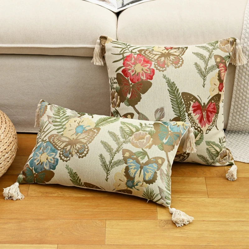 Decorative pillows with butterfly and floral patterns on a wooden floor.