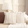 Striped pillows on a sofa with a lamp in the background