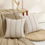 Decorative pillows with striped pattern on a couch with a neutral color scheme.