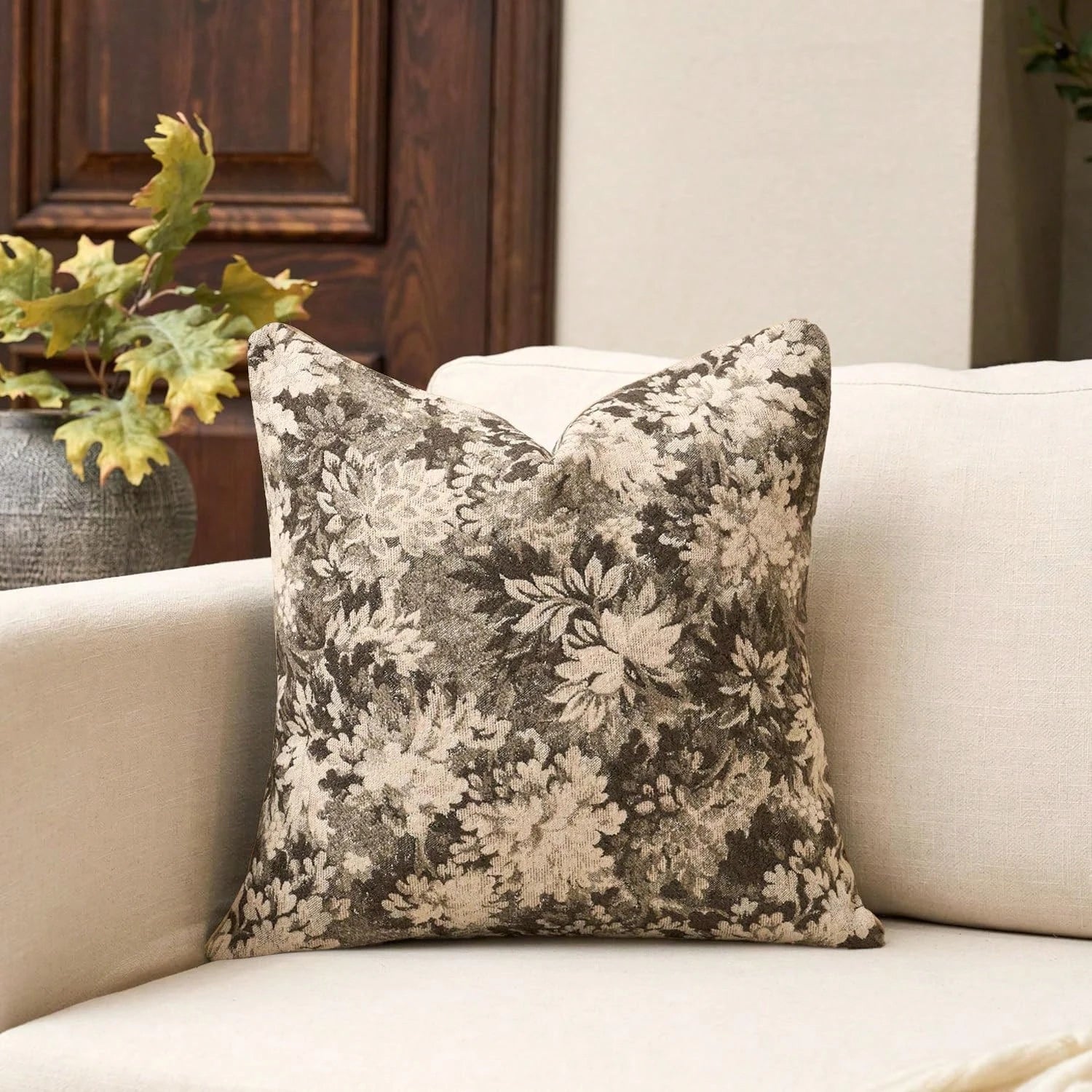 Floral-patterned pillow on a beige sofa with a neutral background