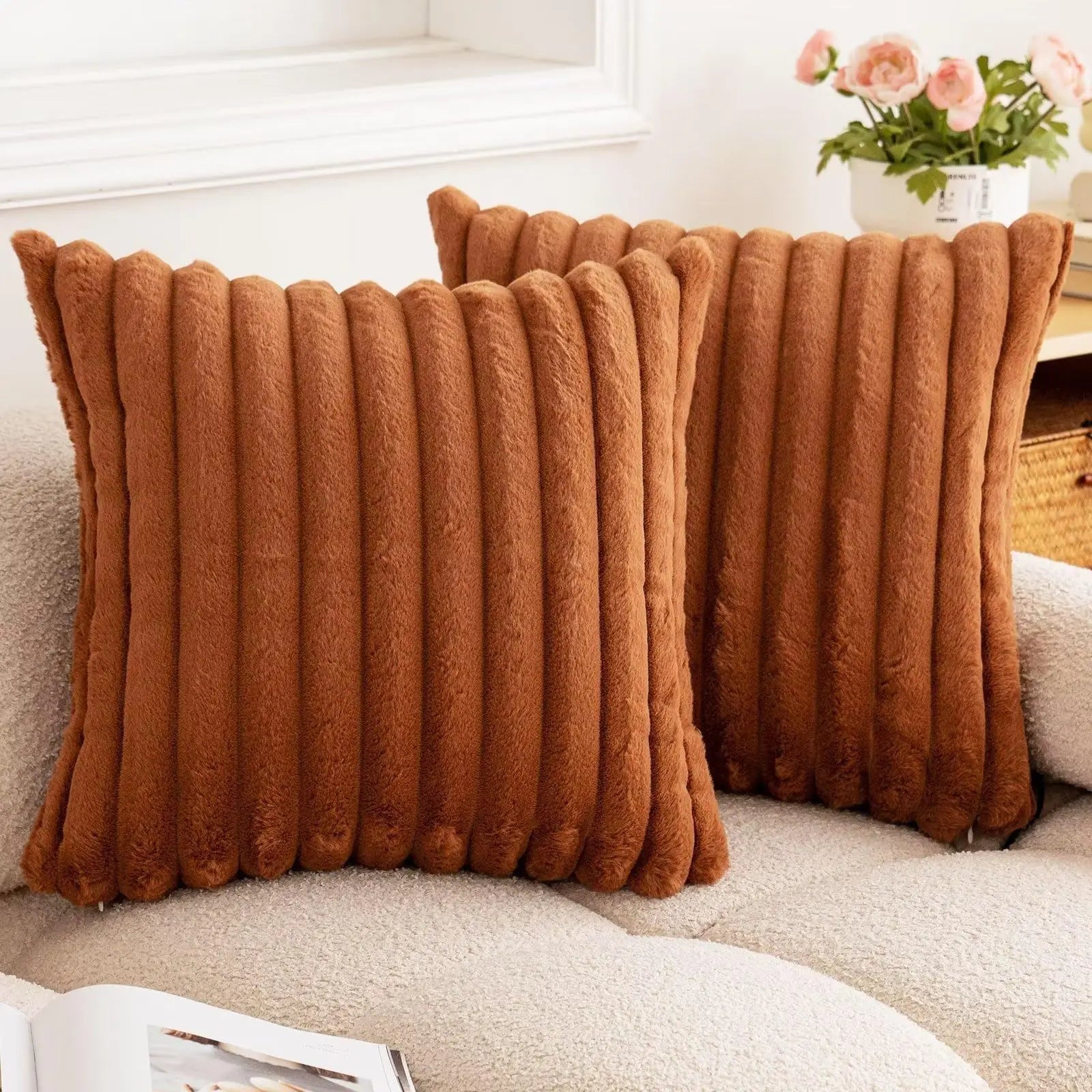Two brown textured pillows on a sofa with a blurred background