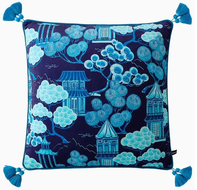 Decorative pillow with blue and white floral and pagoda design on a dark background