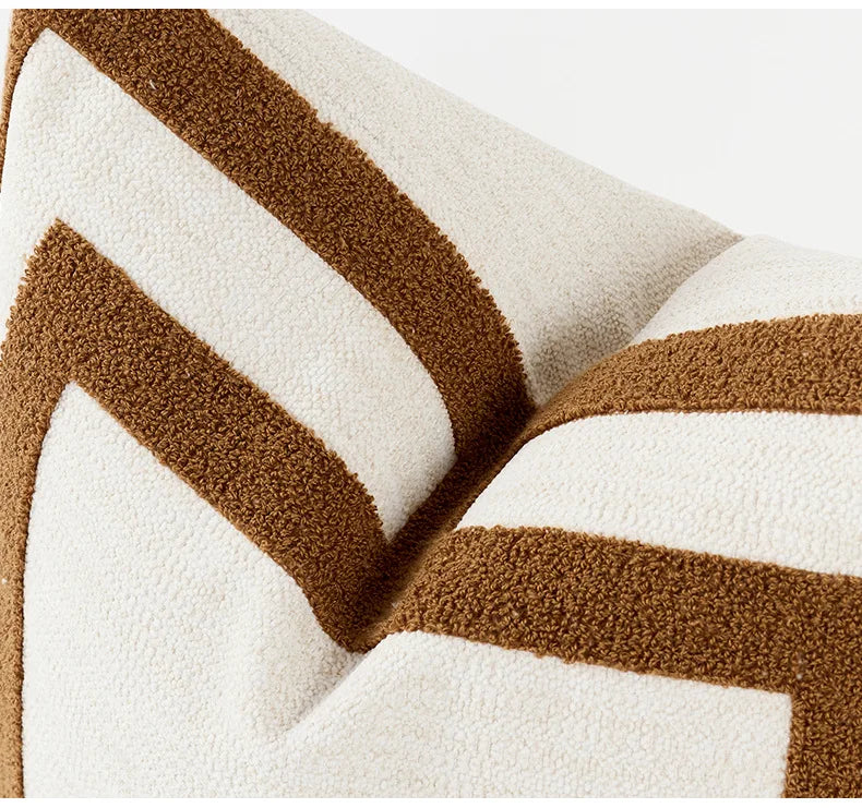 Close-up of a textured blanket with brown and white chevron pattern on a light background