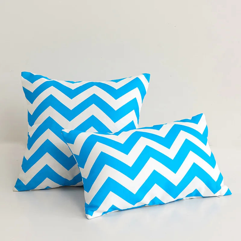 Two blue and white chevron patterned pillows on a light gray background