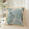 Decorative pillow with leaf pattern on a couch in a living room setting
