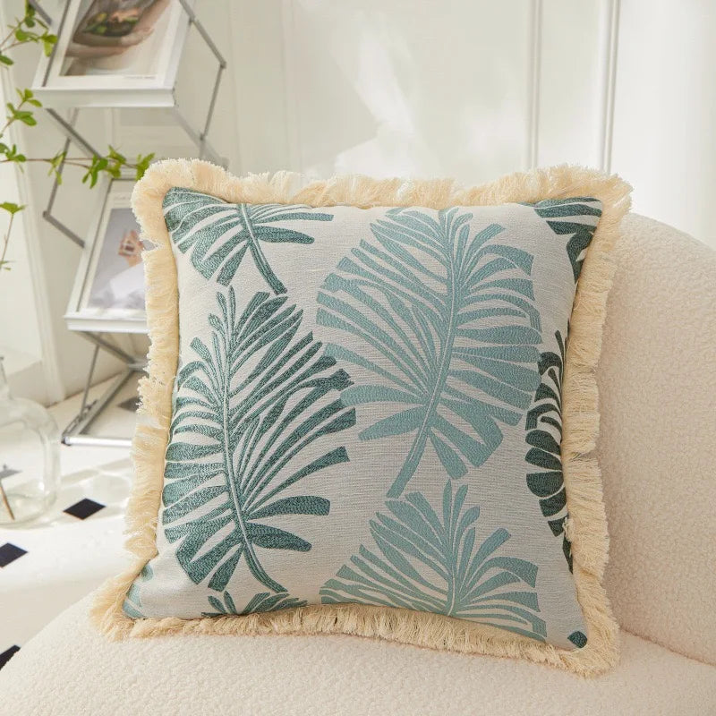 Decorative pillow with leaf pattern on a couch in a living room setting