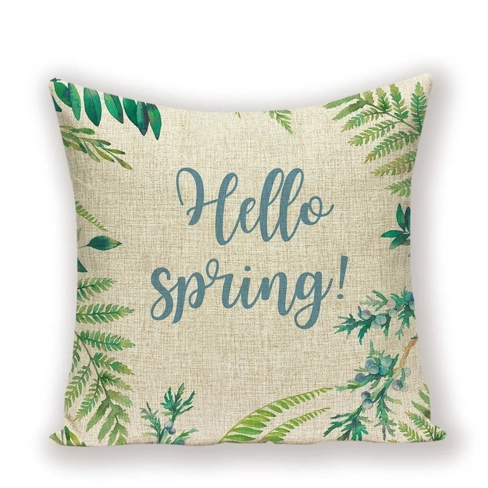 Pillow with 'Hello Spring!' text and green leaf patterns on a beige background