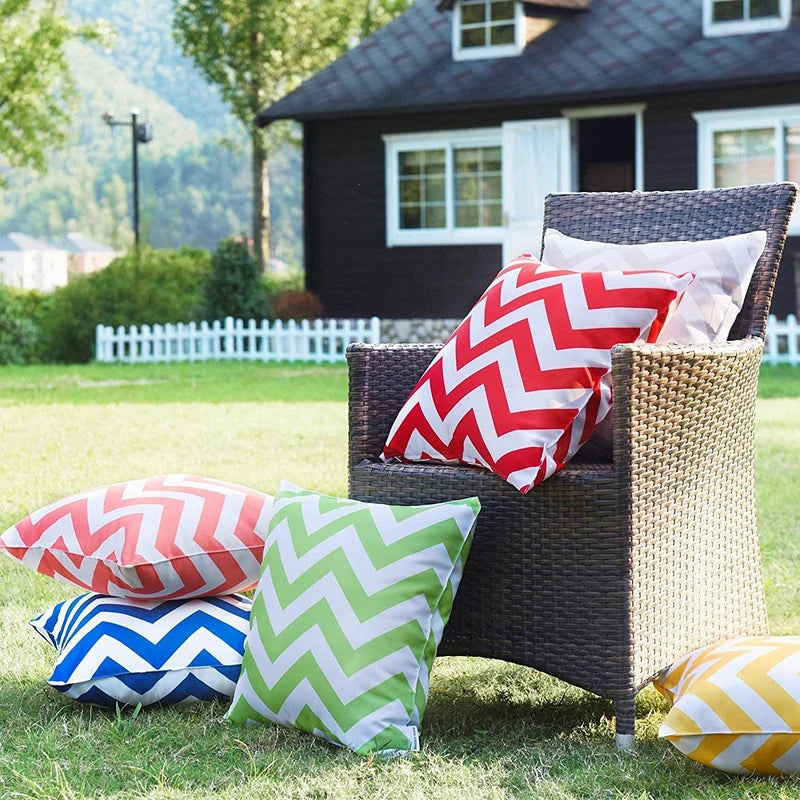 Wicker chair with colorful chevron-patterned cushions on a grassy outdoor setting.