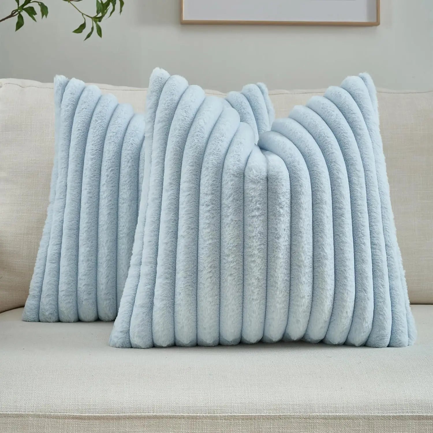 Light blue textured throw pillows on a beige sofa