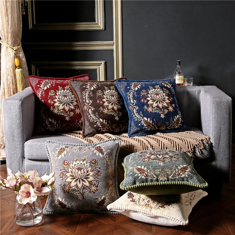 Gray sofa with decorative pillows and a bottle on a dark wall background