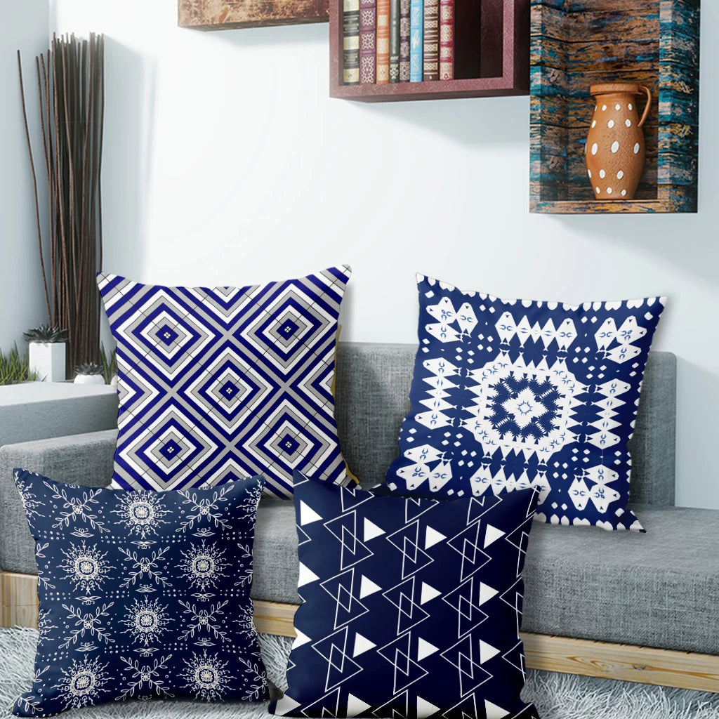 Four blue patterned pillows on a gray sofa with a decorative wall in the background.