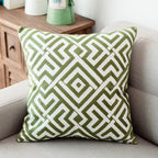 Green and white geometric patterned pillow on a gray sofa