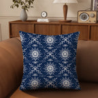 Blue pillow with white snowflake pattern on a brown couch