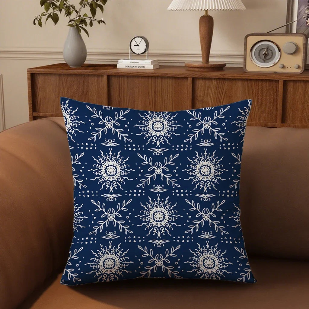 Blue pillow with white snowflake pattern on a brown couch