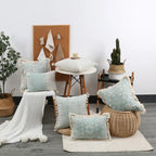 Decorative pillows on a chair and floor with a plant and bulletin board in the background.