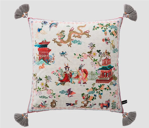 Decorative pillow with intricate patterns and tassels on a light background