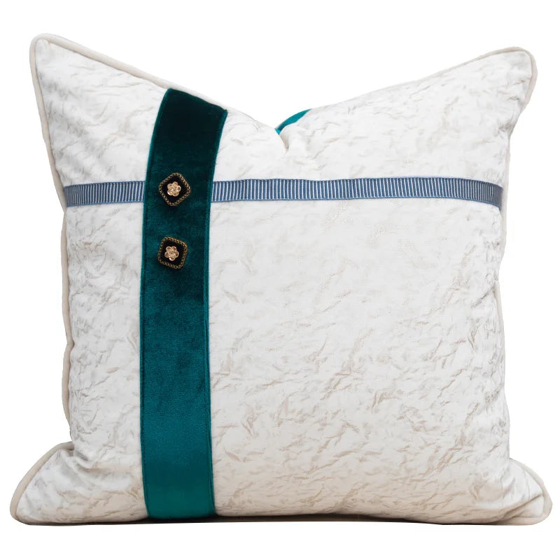 Decorative pillow with a teal ribbon and buttons on a white background