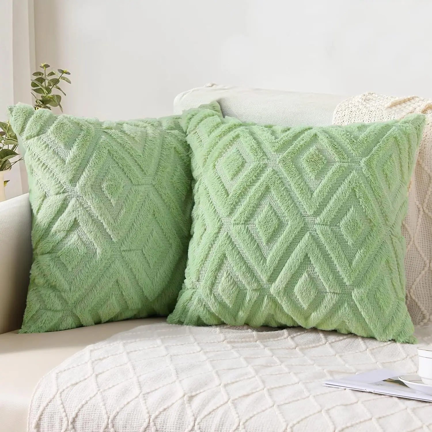Two green textured pillows on a sofa with a neutral background