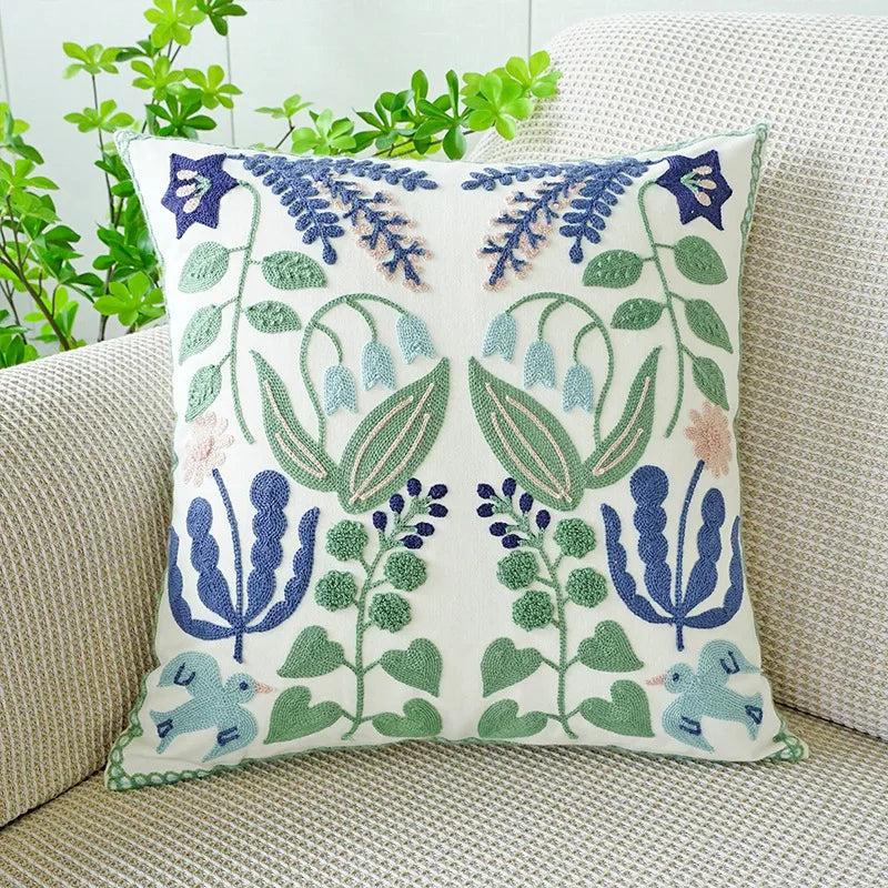 Decorative pillow with floral and bird pattern on a couch