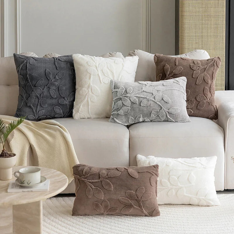 Decorative pillows on a beige sofa in a living room setting.