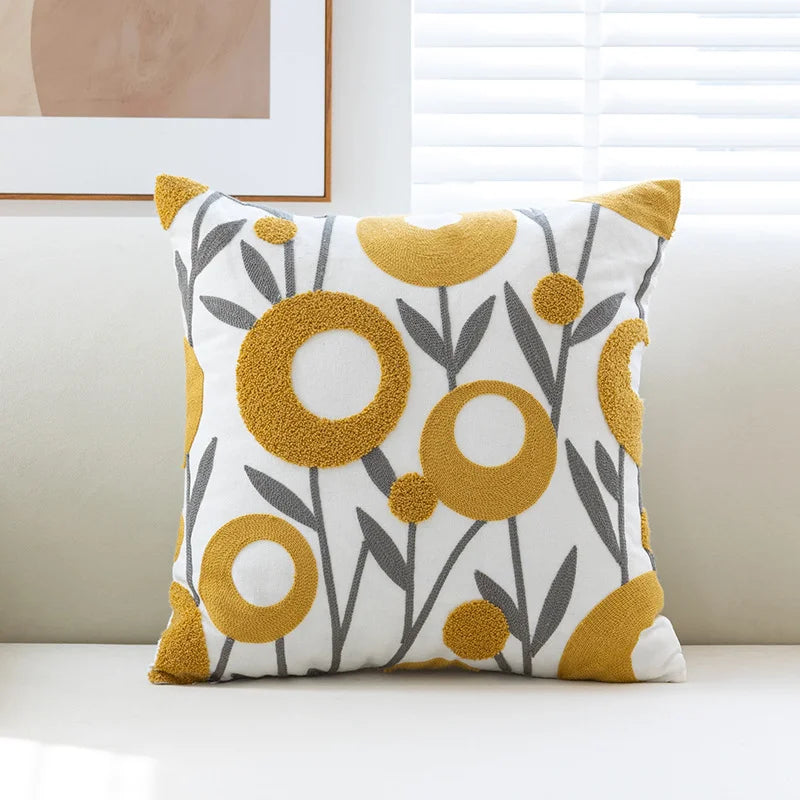 Decorative pillow with yellow and gray floral pattern on a white background