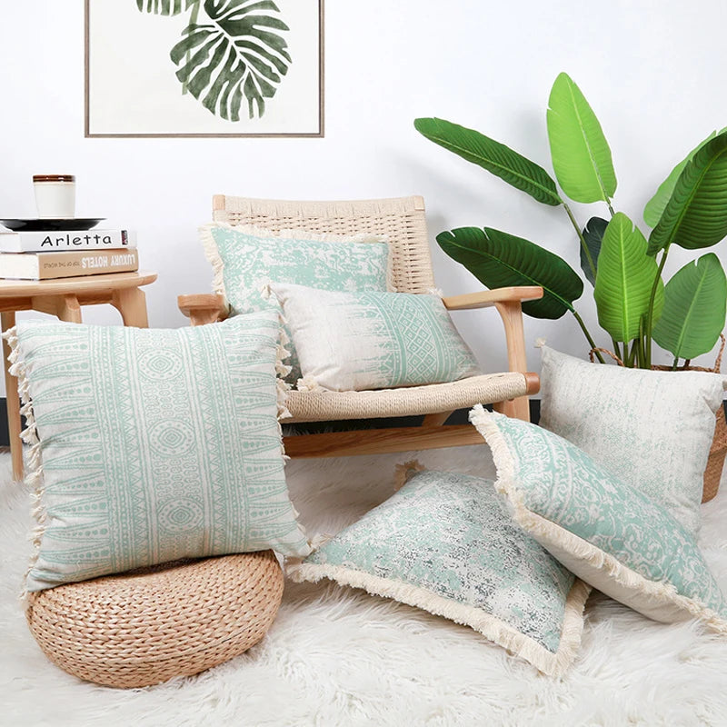 Decorative pillows on a chair with a plant and framed artwork in the background