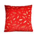 Red pillow with gold leaf pattern on a white background