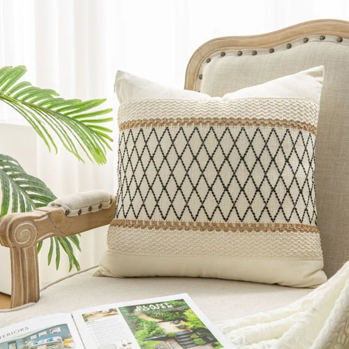 Decorative pillow with geometric pattern on a sofa next to a plant