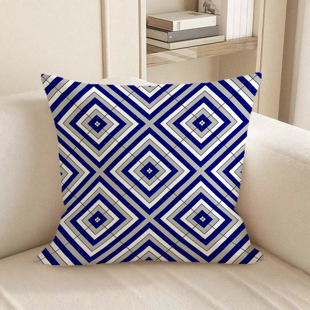 Decorative pillow with blue and white geometric pattern on a beige sofa.