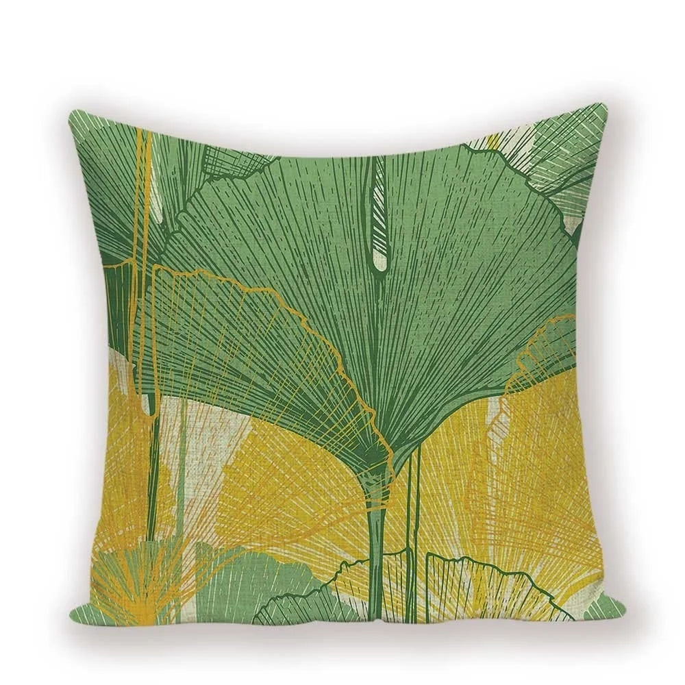 Decorative pillow with green and yellow leaf pattern on a white background