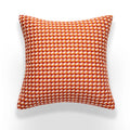 Orange and white checkered pillow on a white background